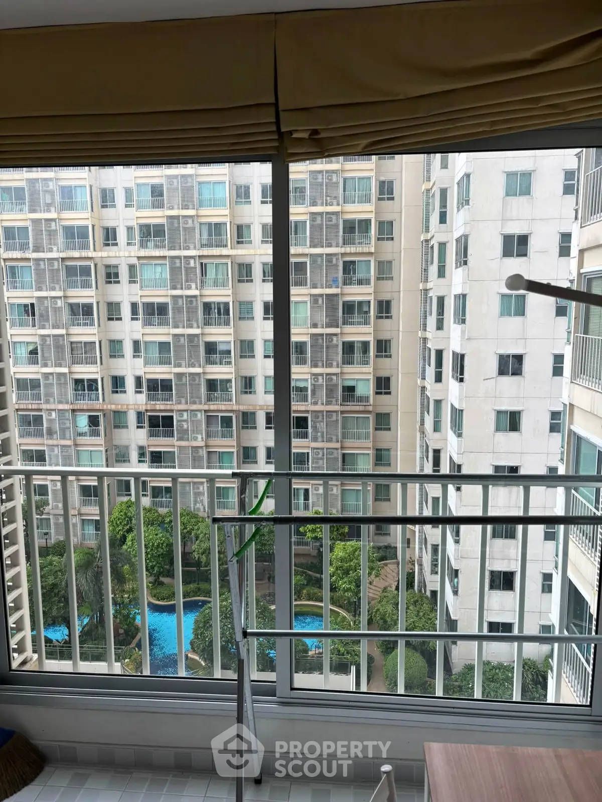 High-rise apartment view with pool and garden from balcony