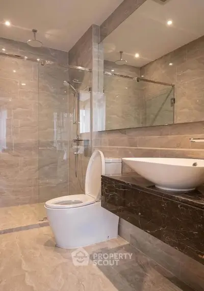 Luxurious modern bathroom with elegant marble finishes and spacious shower area.