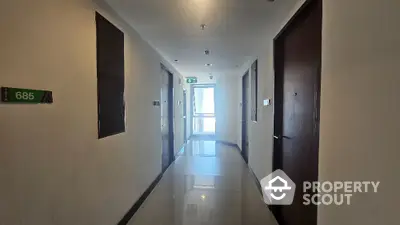 Modern apartment hallway with glossy floors and numbered doors