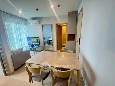Modern open-plan living and dining area with natural light and cozy furnishings.