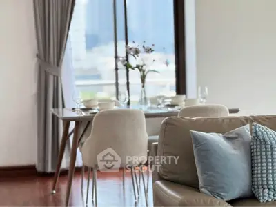 Elegant living room with dining area, featuring modern furniture and city view.