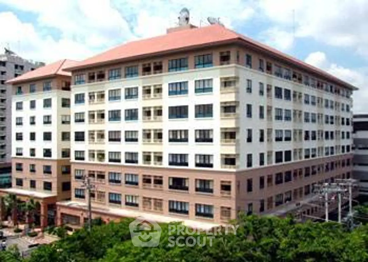 Spacious multi-story residential building with modern design and lush greenery.