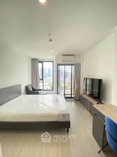 Modern bedroom with city view, featuring a sleek design and natural light.