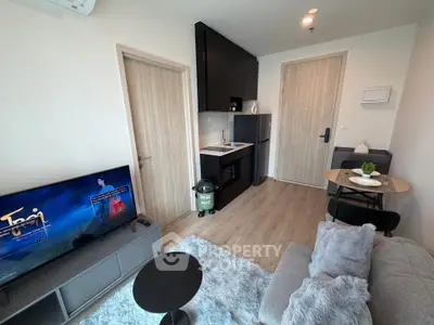 Modern living room with compact kitchen and cozy seating area in stylish apartment.
