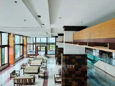 Spacious and elegant living area with modern furniture and large windows offering city views.