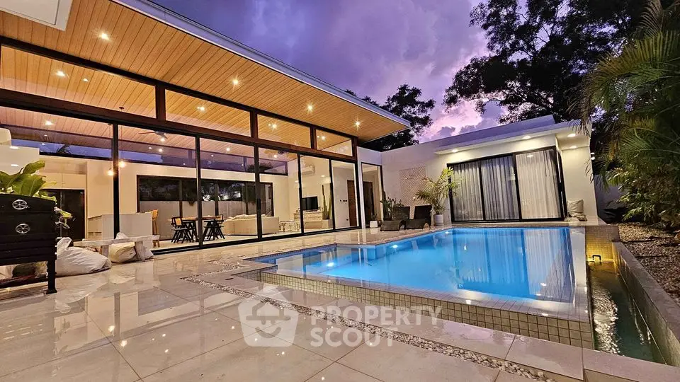 Luxurious modern home with stunning pool and elegant outdoor lighting