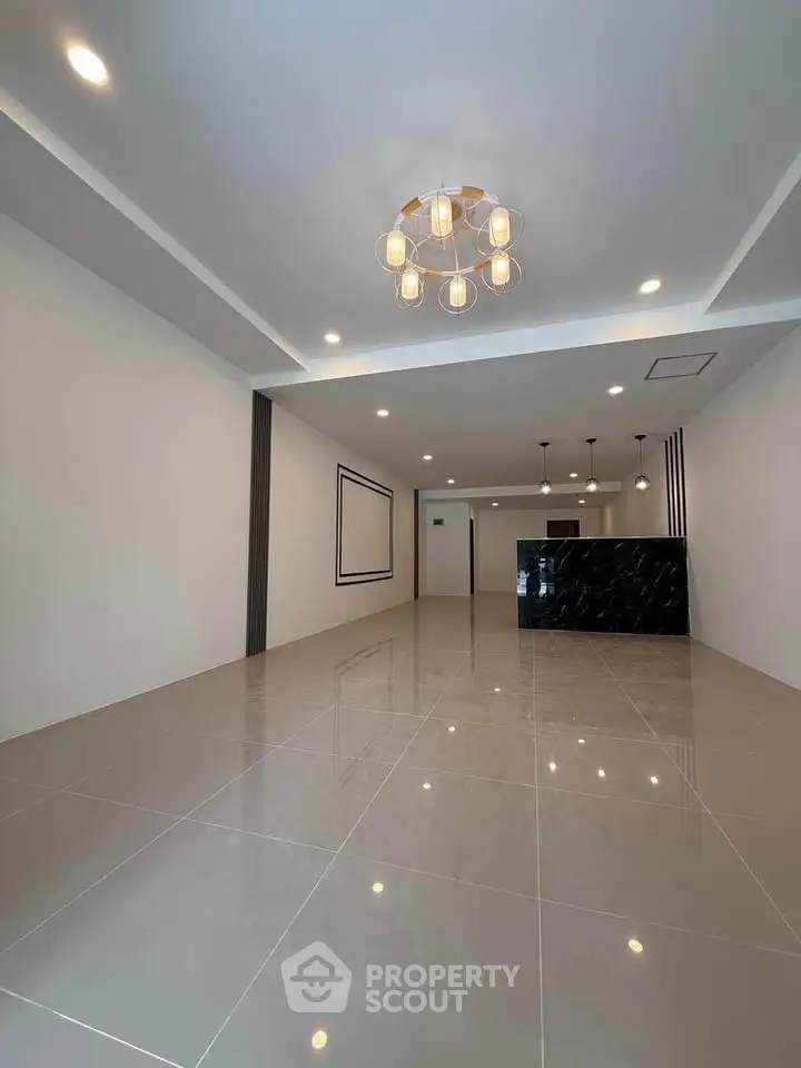 Spacious modern living room with elegant lighting and glossy tiled floor