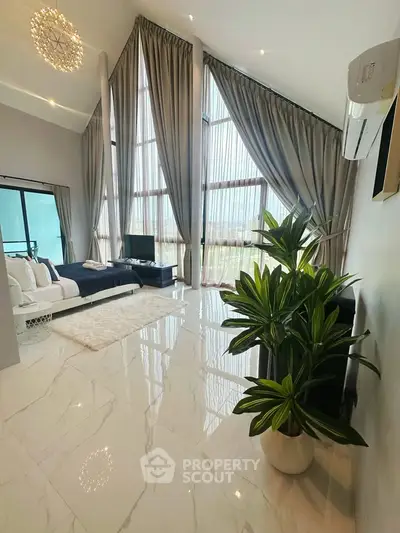 Luxurious living room with high ceilings, large windows, and elegant decor in a modern apartment.