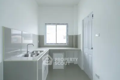 Modern minimalist kitchen with sleek countertops and ample natural light