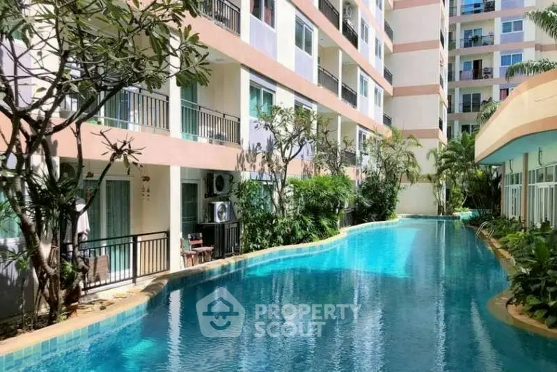 Luxurious apartment complex with stunning poolside view and lush greenery.