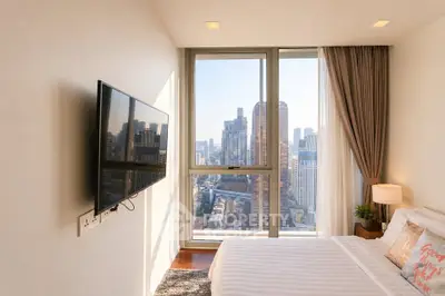 Modern bedroom with city view, large window, and wall-mounted TV in a high-rise apartment.