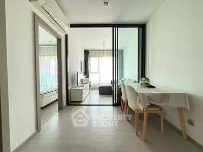 Modern apartment interior with open living and dining area, featuring sleek furniture and natural light.