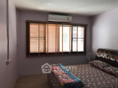 Cozy bedroom with large window and air conditioning, perfect for relaxation.