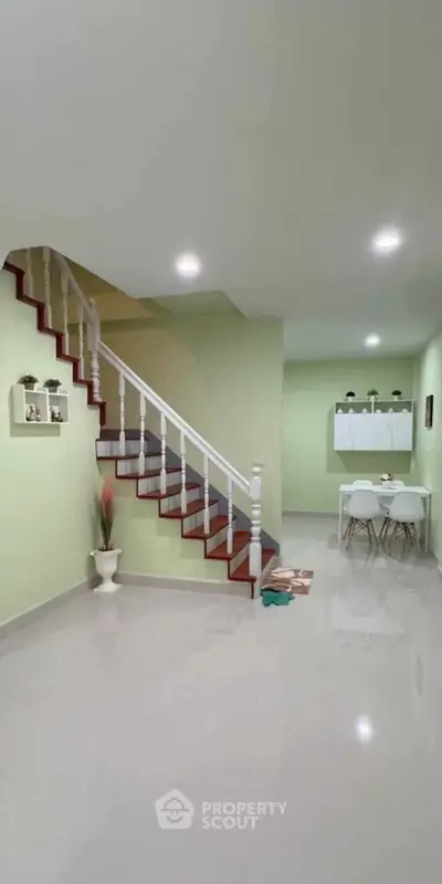 Modern interior with sleek staircase and dining area, perfect for contemporary living.