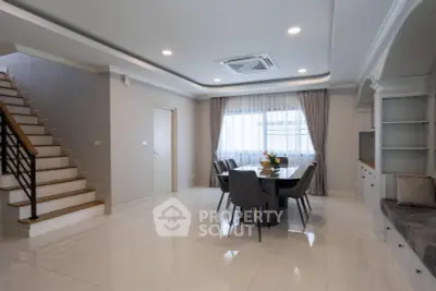 Elegant dining area with modern furniture and staircase in a spacious living room