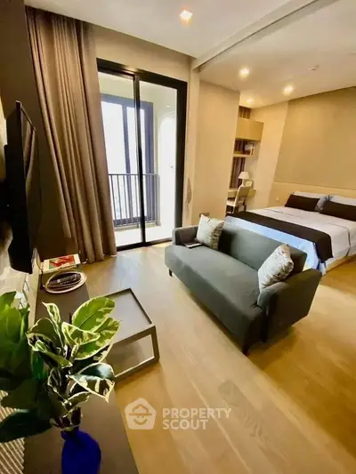 Modern studio apartment with cozy living area and balcony access, featuring stylish decor and natural light.