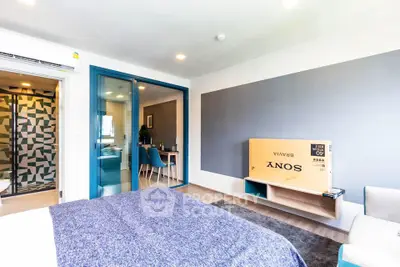 Modern bedroom with stylish decor and sliding glass doors leading to dining area.