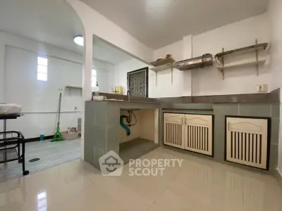 Spacious kitchen with open layout and modern design, featuring ample storage and sleek countertops.