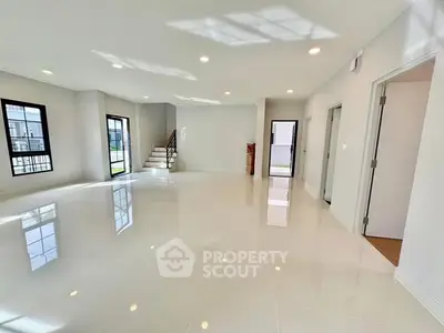 Spacious modern living room with glossy floors and ample natural light