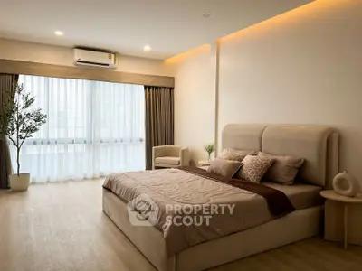 Spacious and elegant bedroom with modern decor and large window view.