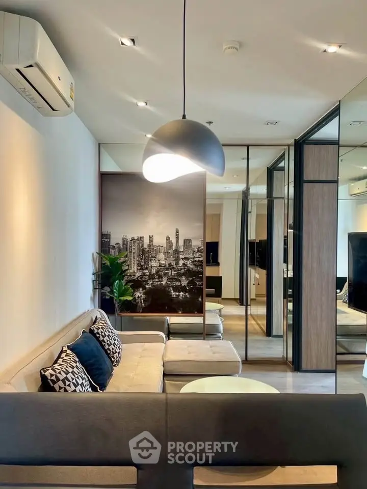 Modern living room with stylish decor and cityscape artwork, featuring a cozy sofa and elegant lighting.