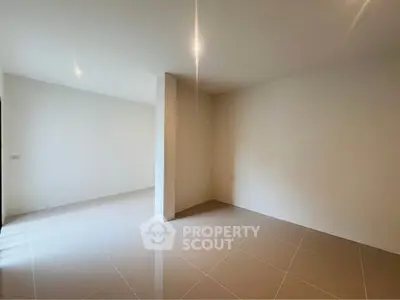 Spacious empty room with tiled flooring and bright natural light, perfect for customization.
