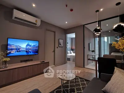 Modern living room with stylish decor and open view to bedroom, featuring sleek furniture and ambient lighting.