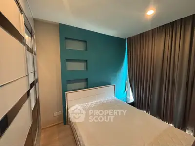 Modern bedroom with stylish teal accent wall and cozy lighting