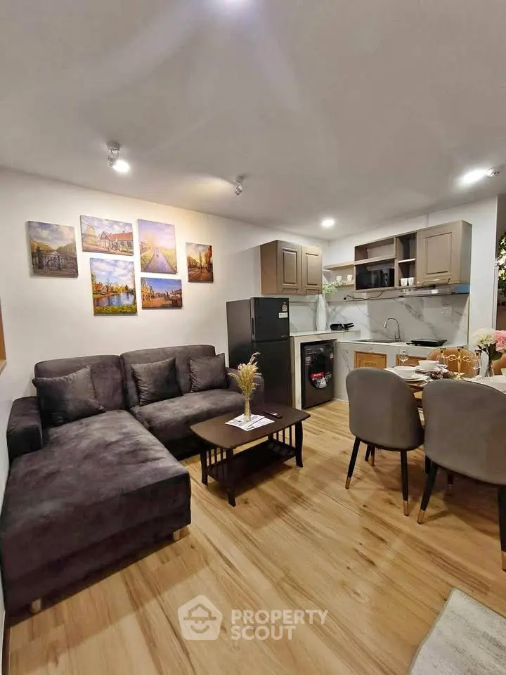 Modern open-layout living room with cozy seating and stylish kitchen area.