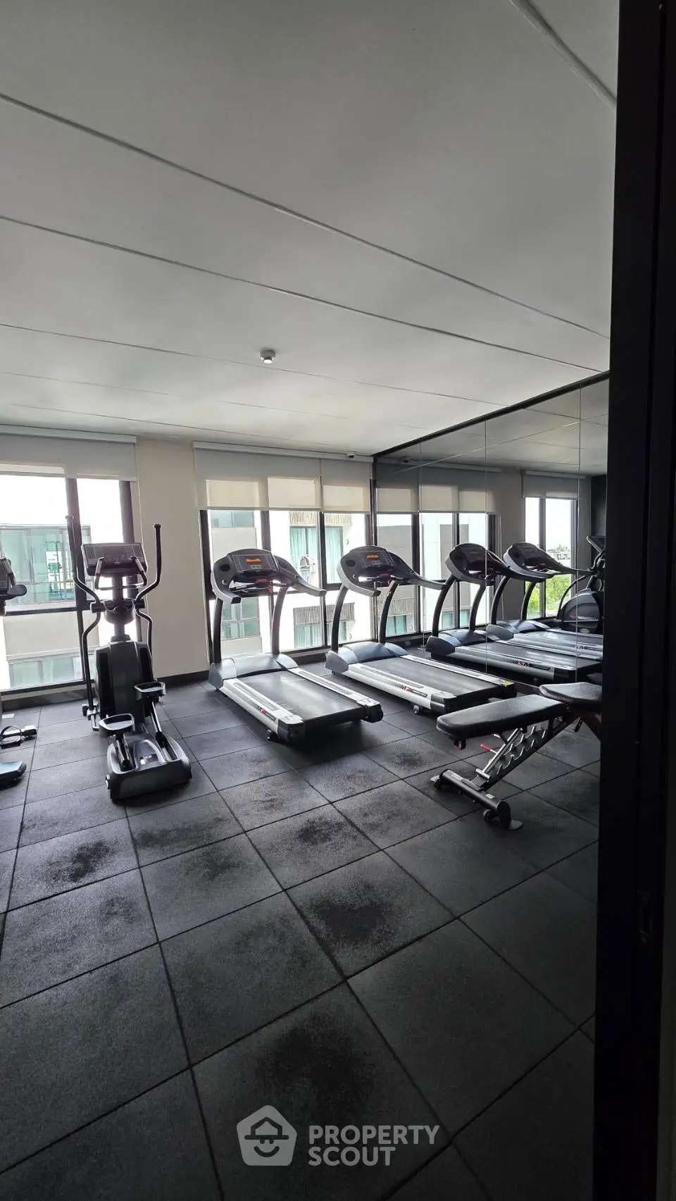 Modern gym with treadmills and exercise equipment in a bright, spacious room.