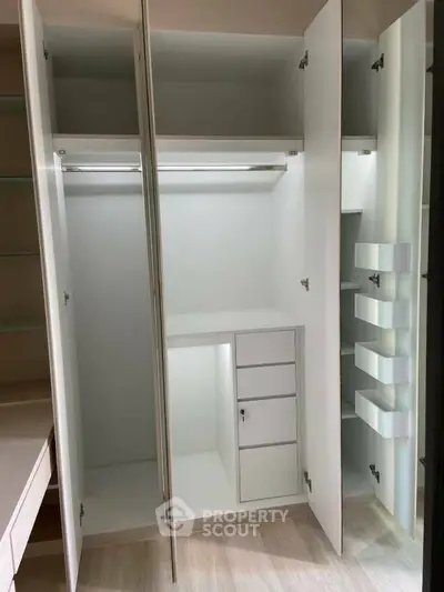 Spacious white walk-in closet with ample storage and sleek design