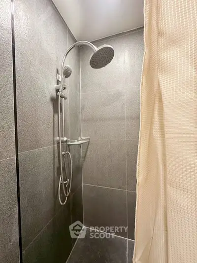 Modern shower area with sleek grey tiles and rainfall showerhead