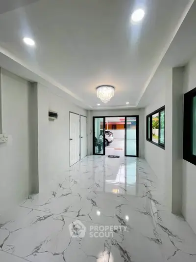 Spacious modern living room with marble flooring and elegant chandelier
