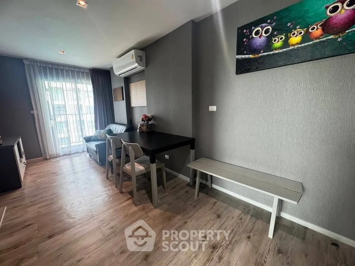 Modern living room with stylish decor and natural light, featuring a cozy seating area and contemporary artwork.