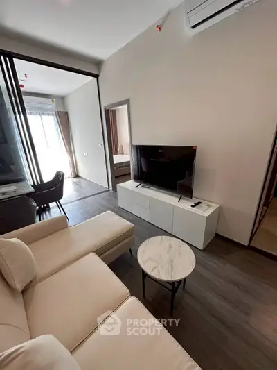 Modern living room with sleek furniture and natural light in a stylish apartment.