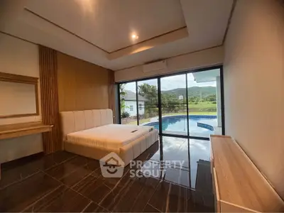 Luxurious bedroom with pool view and modern design, featuring large windows and elegant furnishings.