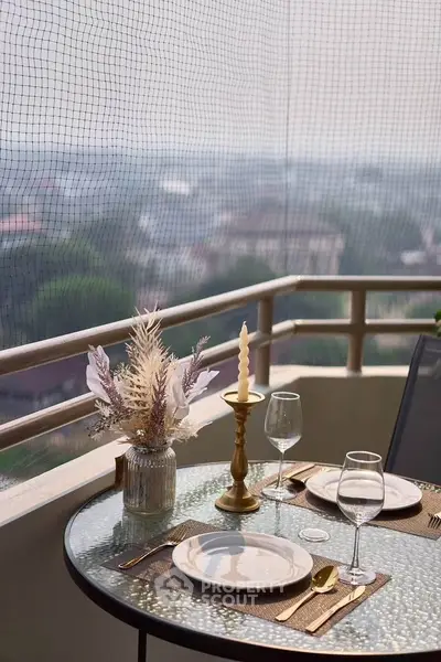 Charming balcony with elegant dining setup and scenic view, perfect for outdoor relaxation.