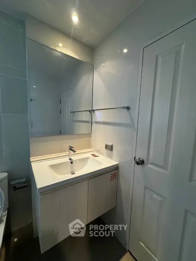 Modern bathroom with sleek sink and large mirror in contemporary home