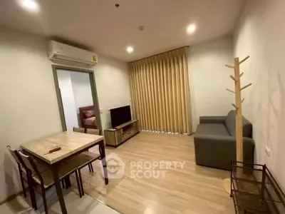 Modern living room with cozy sofa, dining table, and TV, perfect for relaxation and entertainment.