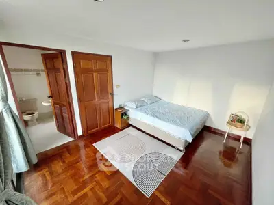 Spacious bedroom with ensuite bathroom and wooden flooring, perfect for cozy living.