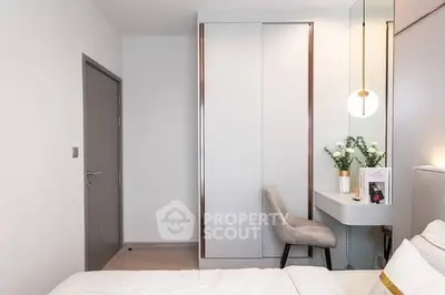 Modern bedroom with sleek design, featuring a built-in wardrobe and stylish vanity area.