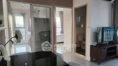 Modern apartment interior with open layout, featuring dining area, kitchen, and cozy living space with natural light.