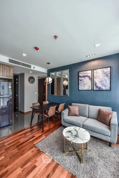 Modern living room with stylish decor, wooden flooring, and elegant furniture in a contemporary apartment.