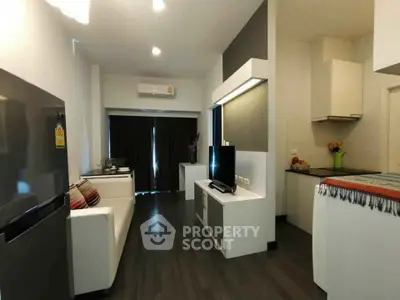 Modern living room with sleek furniture and open kitchen layout in a stylish apartment.