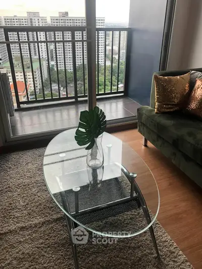 Stylish living room with glass coffee table and balcony view in modern apartment.