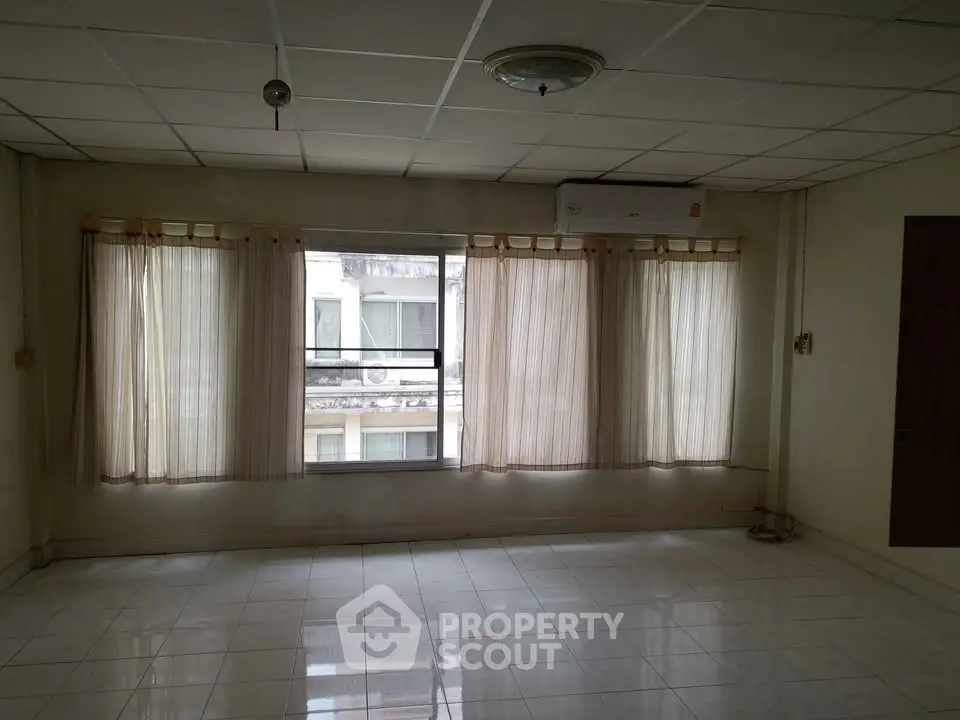 Spacious empty room with large windows and tiled floor, ideal for customization.