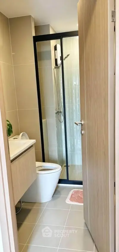 Modern bathroom with glass shower and sleek fixtures in a contemporary apartment.