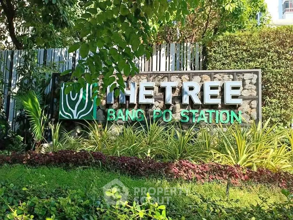 Lush green entrance of The Tree Bang Po Station with vibrant landscaping.
