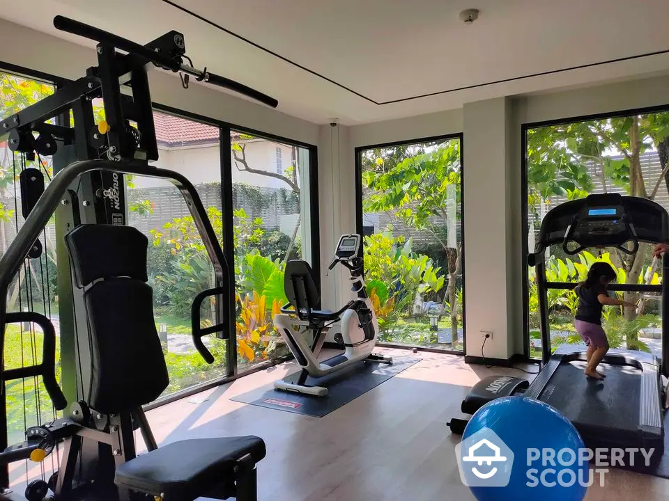 Modern home gym with large windows and garden view