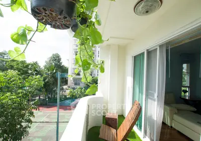 Charming balcony with lush greenery and cozy seating overlooking tennis court